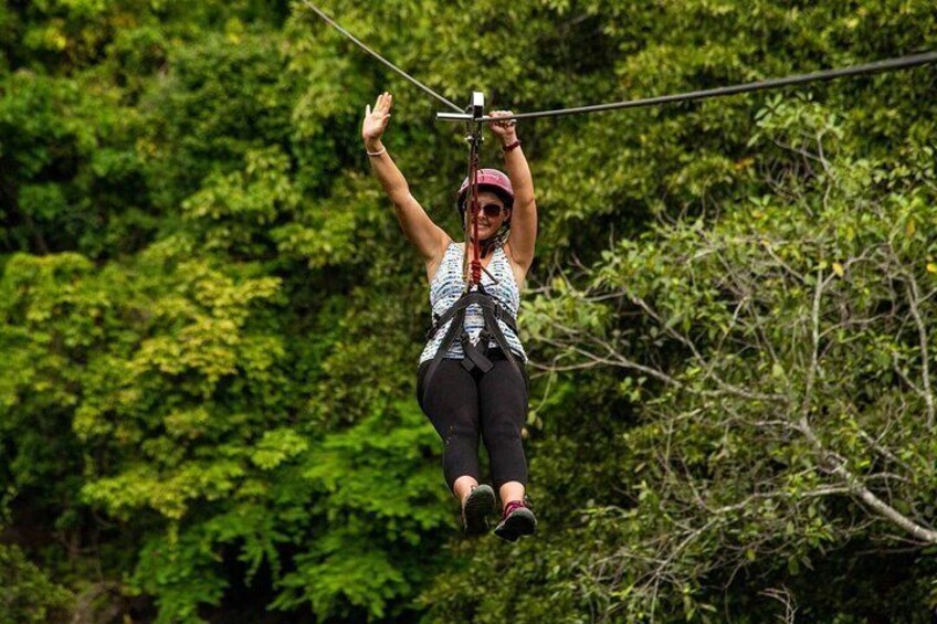 A person ziplining through a forest. 1