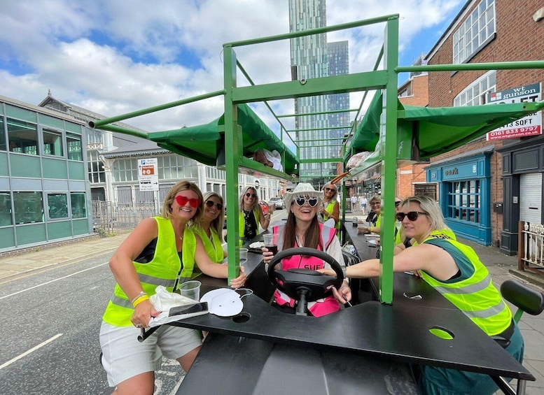 A group of people in a green vehicle with a steering wheel, parked on a street with buildings and a sign for 'Great Northern Putterfield'. 1