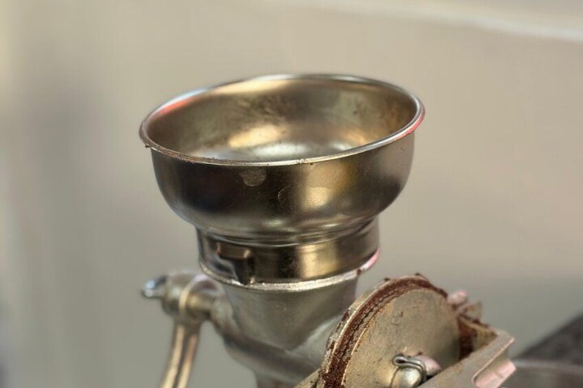 A metallic object with a bowl-like top, attached to a cylindrical base with a valve. 3