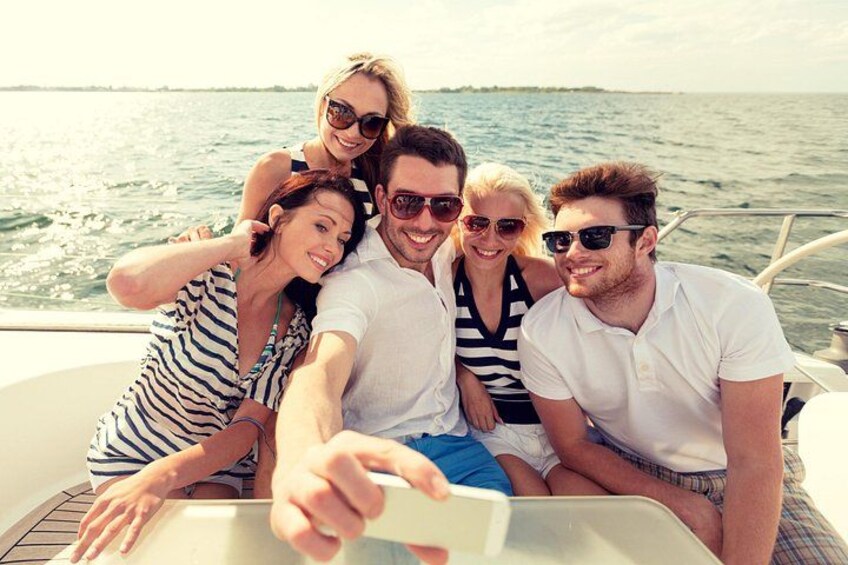 A group of people on a boat with a body of water and a distant shoreline in the background. 2