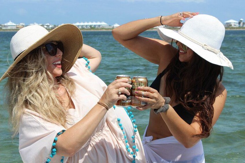 Two people by a body of water, one holding a drink. 5
