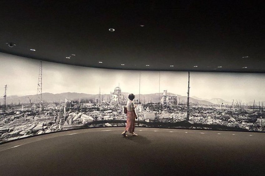 A person standing in a room with a panoramic view of a cityscape. 4