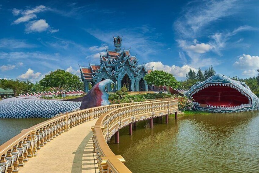 A bridge leading to a temple with a dragon statue and a large dragon mouth sculpture. 4