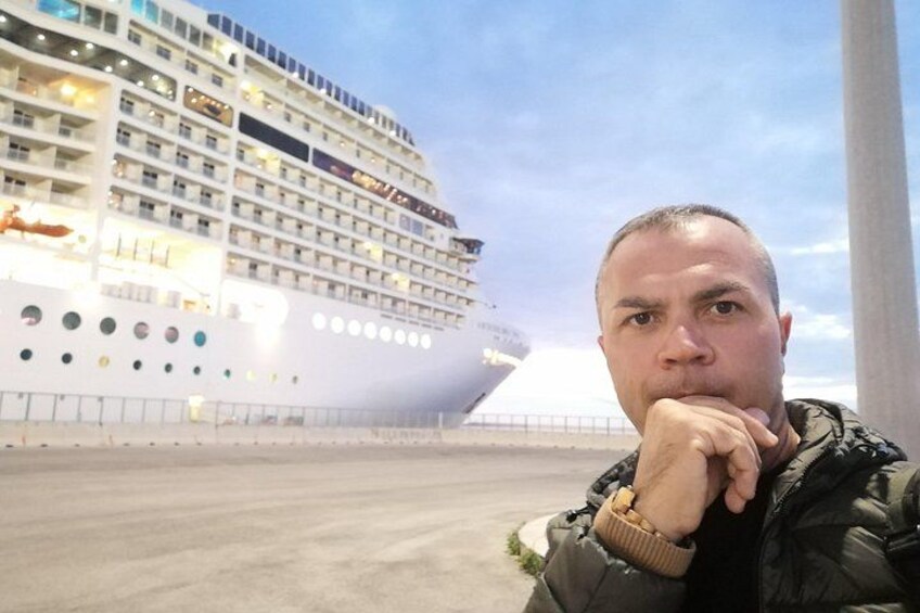 Eine Person steht vor einem Kreuzfahrtschiff. 5