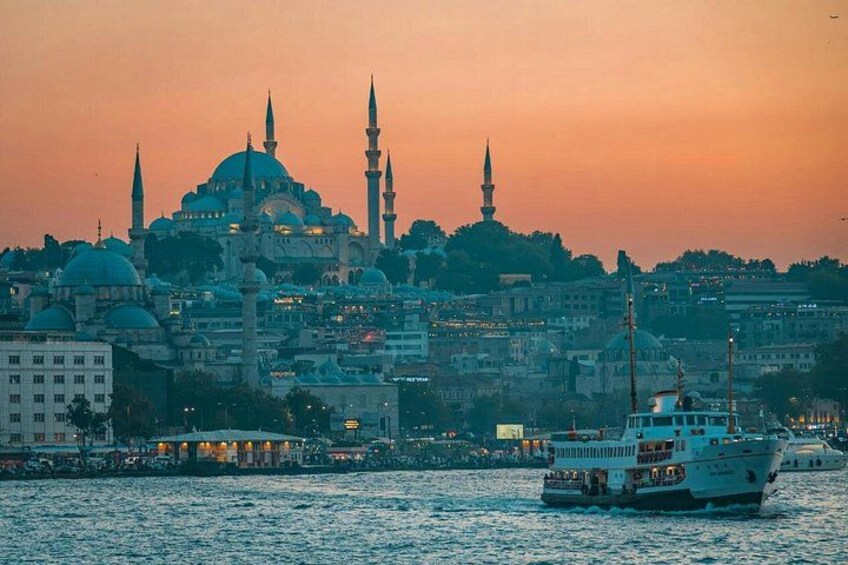 A cityscape with a prominent mosque with a large dome and two minarets, a river with a boat, and a sunset sky. 2