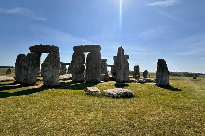 Stonehenge in einem grasbewachsen Feld unter blauem Himmel. 1