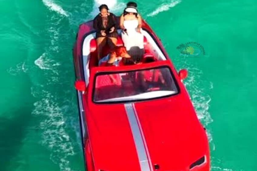 Un bateau rouge avec deux personnes à bord, naviguant sur une eau turquoise. 5