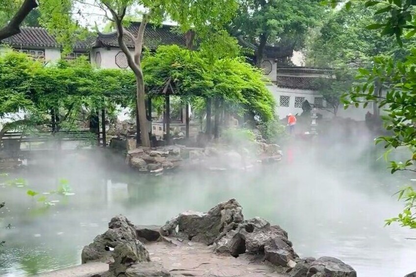 Un jardín tradicional con aguas termales, rocas y árboles. 4