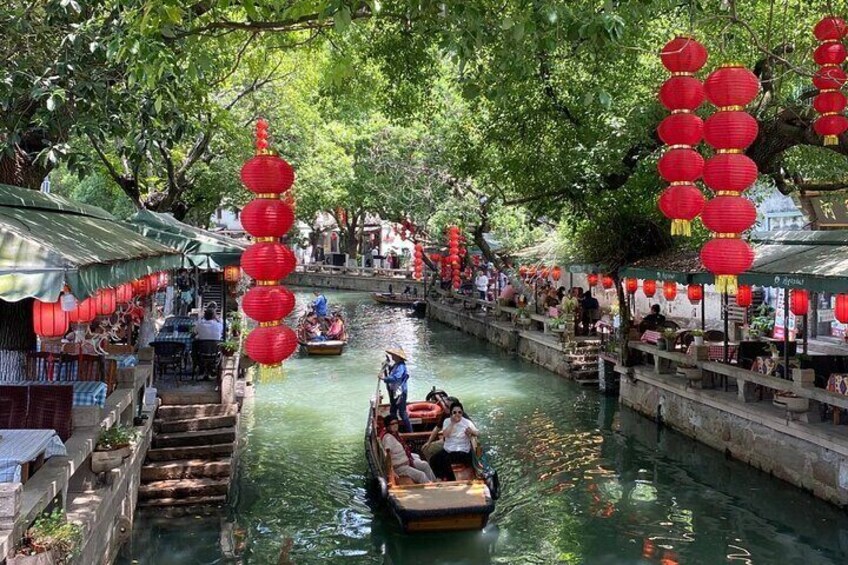 Un canal estrecho con barcos, faroles rojos y edificios tradicionales. 1