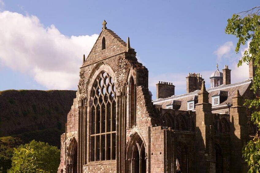 A historic stone building with large arched windows and a steeply pitched roof. 2