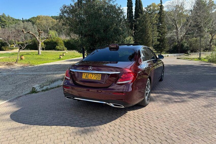 En mørkegrøn Mercedes-Benz med synlig nummerplade TAE-7708 parkeret på en asfalteret indkørsel. 4