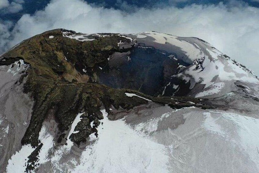 A snow-covered mountain with a visible crater. 5
