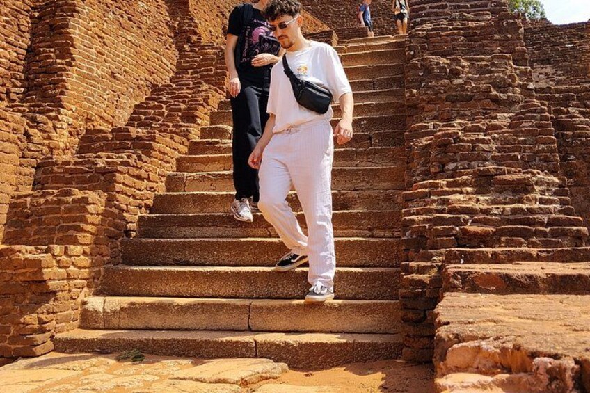 A person descending a stone staircase in a historical site. 5