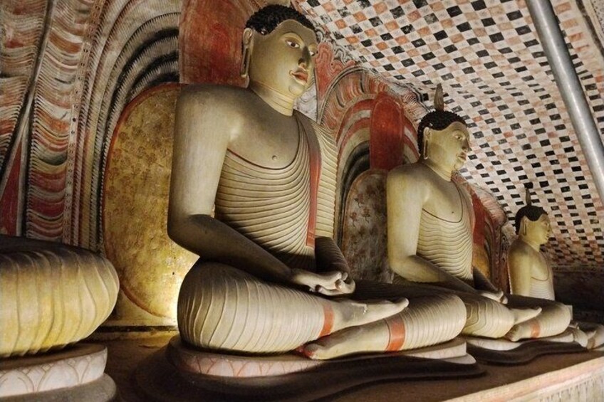 A large Buddha statue in a meditative pose, surrounded by smaller statues and intricate wall designs. 3