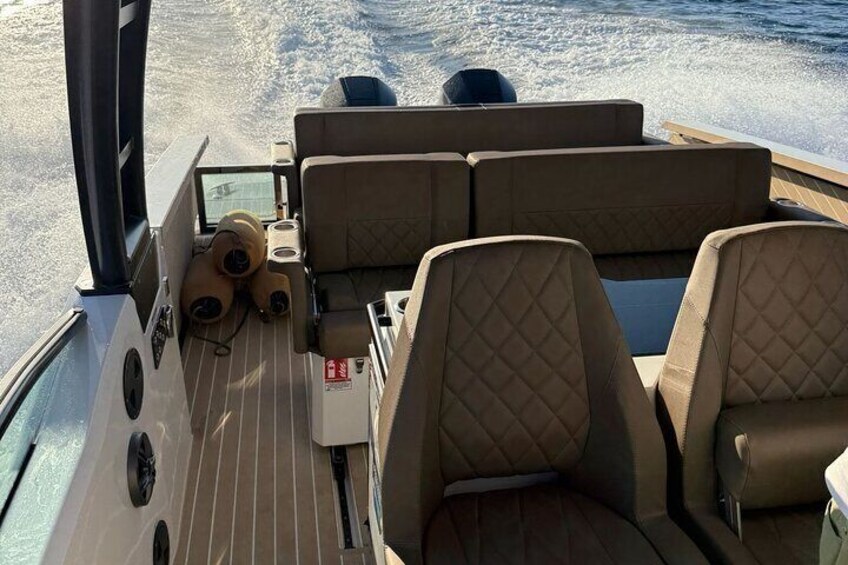 Ett båtdäck med bekväma sittplatser och ett litet bord. 2