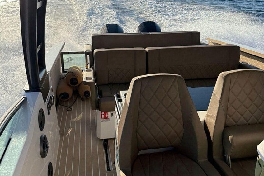 Ett båtdäck med bekväma sittplatser och ett litet bord. 2