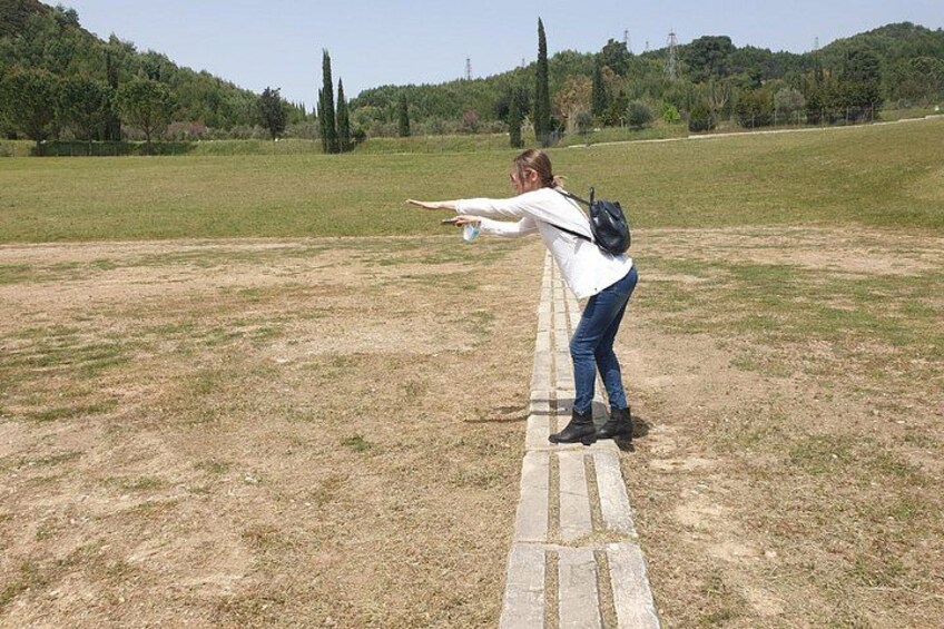 A person aiming a bow and arrow in an open field. 2