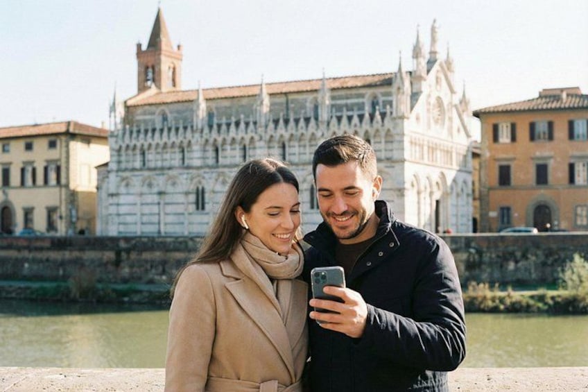 A couple standing in front of a historic building with a river in the background. 5