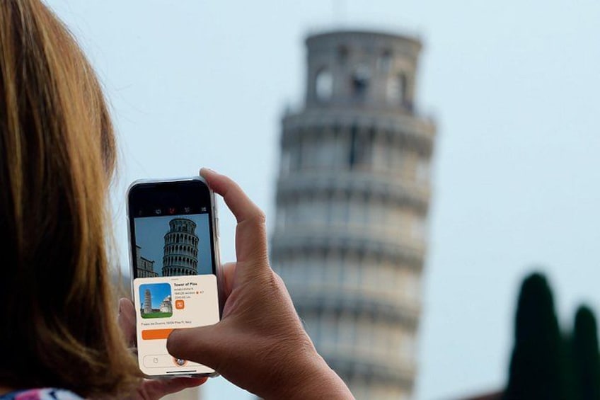 A person holding a smartphone with a photo of the Leaning Tower of Pisa. 1