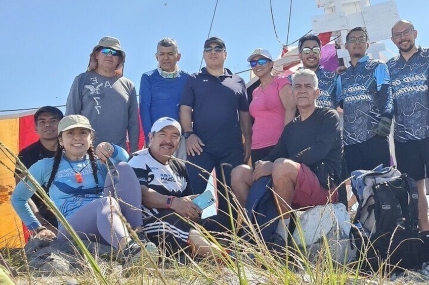 A group of people outdoors, some wearing athletic gear, with a clear sky in the background. 2