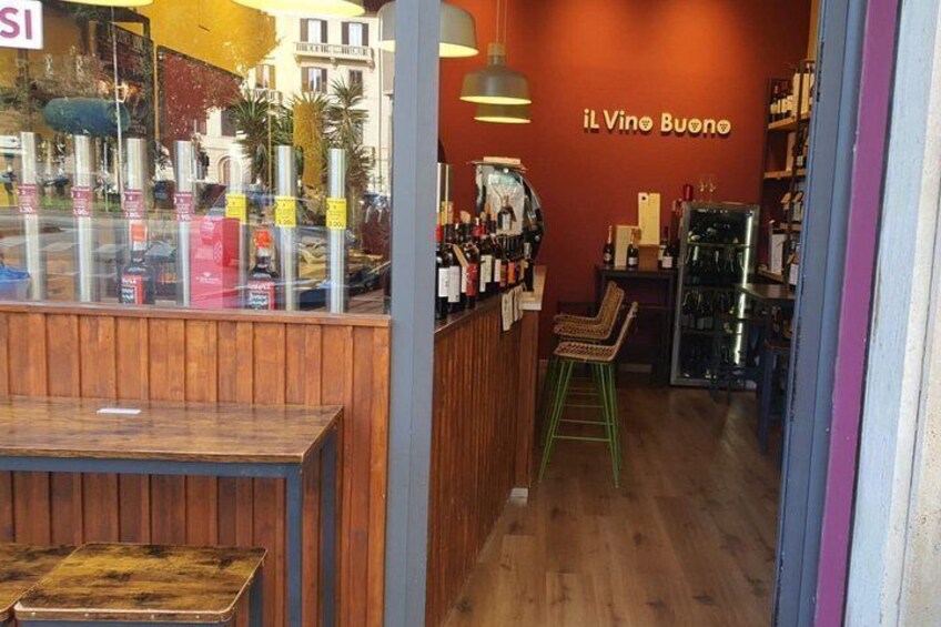 A cozy bar with wooden furniture and a red wall. 2