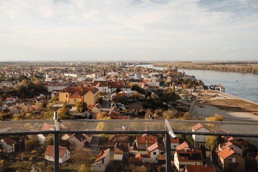 A river with a town on the opposite bank, a bridge, and a fence in the foreground. 4
