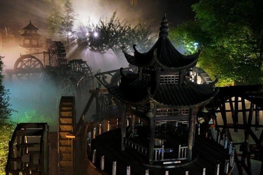 Eine traditionelle chinesische Pagode mit einer umlaufenden Holzumzäunung, einem Wasserrad und verschwommenem Hintergrund. 2