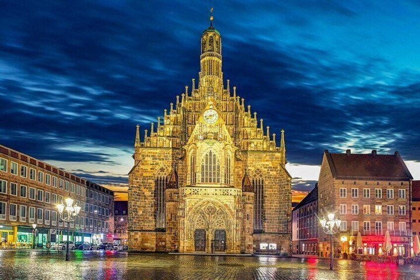 Een historisch kerkgebouw met ingewikkelde architectuur, een klokkentoren en een spiegelbeeld in het water. 2
