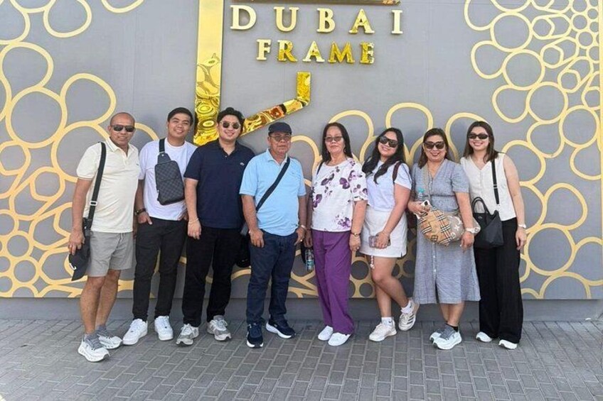 Un grupo de personas posando frente al letrero del Dubai Frame. 1