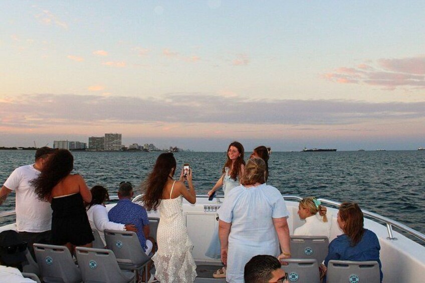 A group of people on a boat with a city skyline in the background. 4