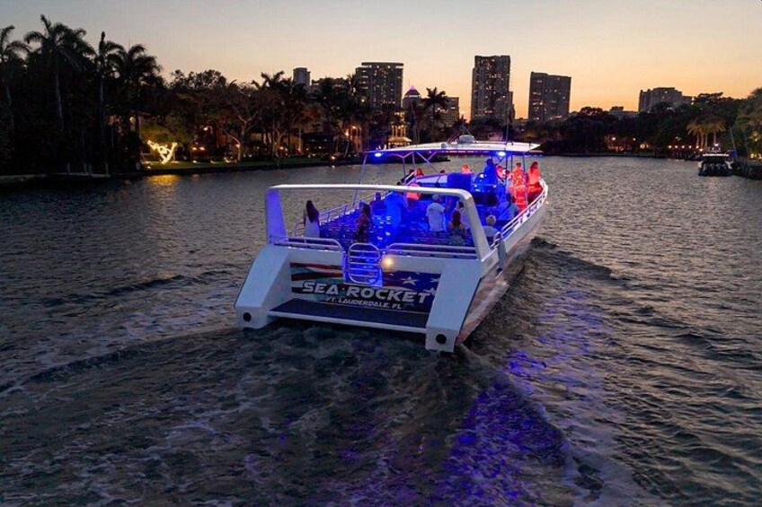 A boat named 'SEA ROCKET' with illuminated blue lights on a body of water. 3