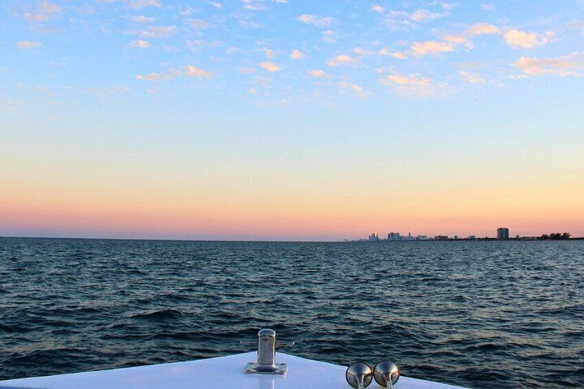 A body of water with a city skyline in the distance during sunset. 5