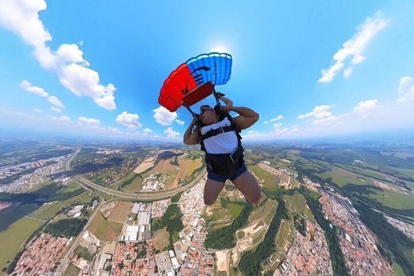 A person skydiving with a parachute above a cityscape. 2