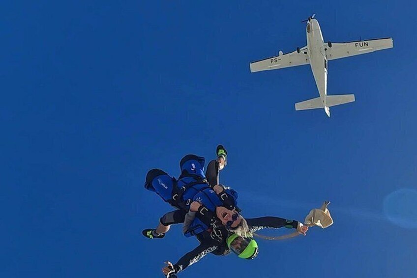 A skydiver in freefall with a parachute, and a small aircraft labeled 'FUN' in the background. 5