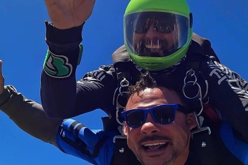 A person skydiving with a parachute, wearing a helmet and a jumpsuit. 4