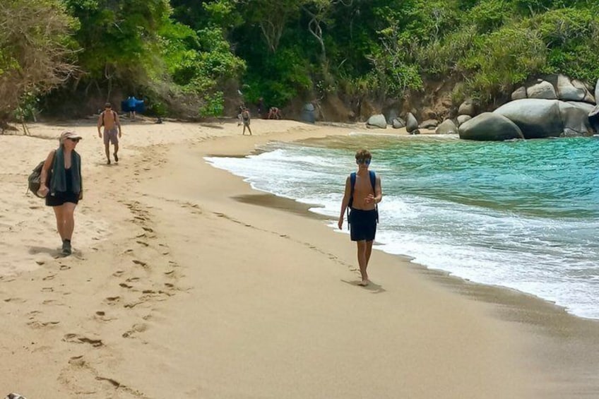 A sandy beach with people walking and a calm sea. 5