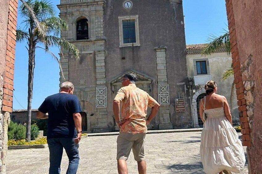 Tre persone in piedi di fronte a un edificio storico con una torre dell'orologio. 5