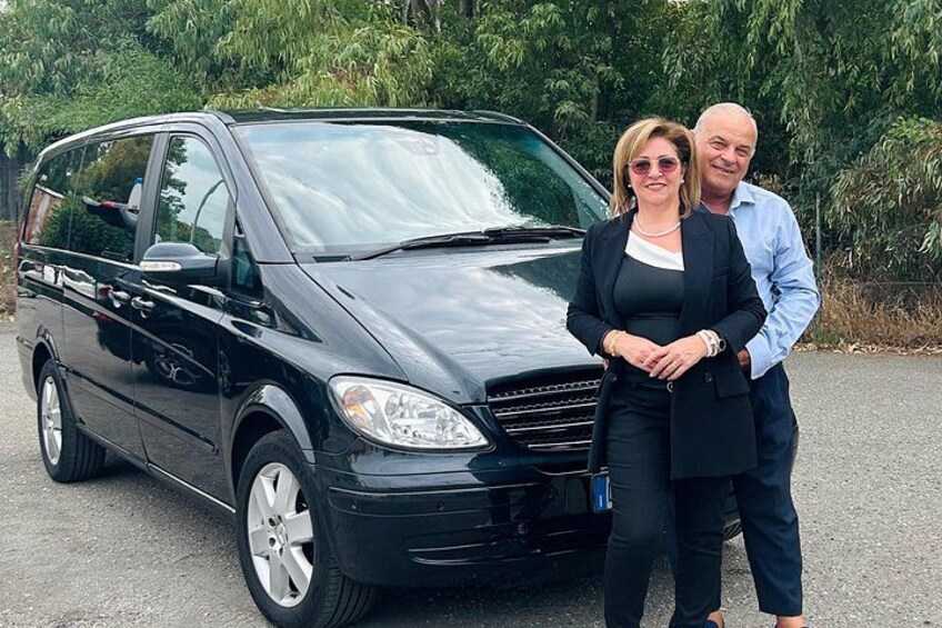 Un minivan nero parcheggiato su una strada, con alberi sullo sfondo. 3