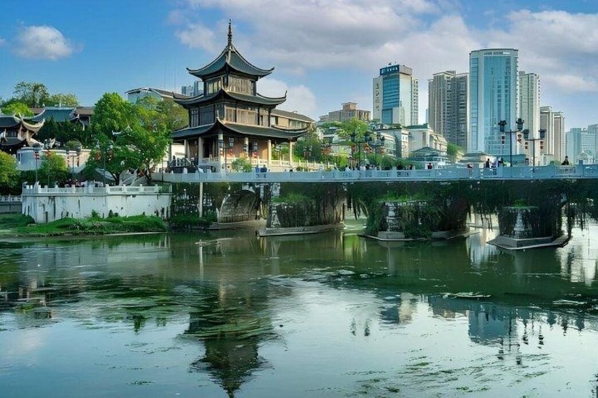 A traditional pagoda by a calm river with a city skyline in the background. 4