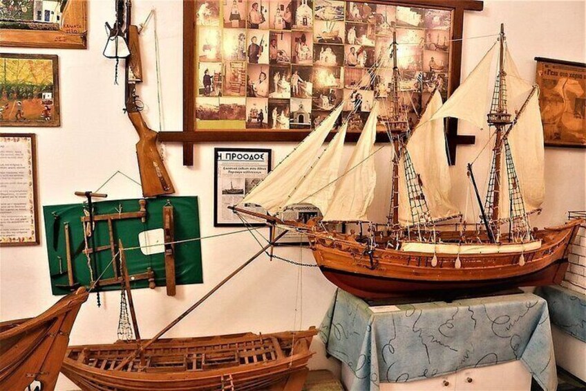 A model ship on display, surrounded by various maritime artifacts and historical documents. 5