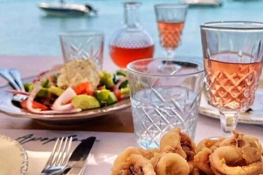 A table with a plate of food, a glass of drink, and a bottle. 2