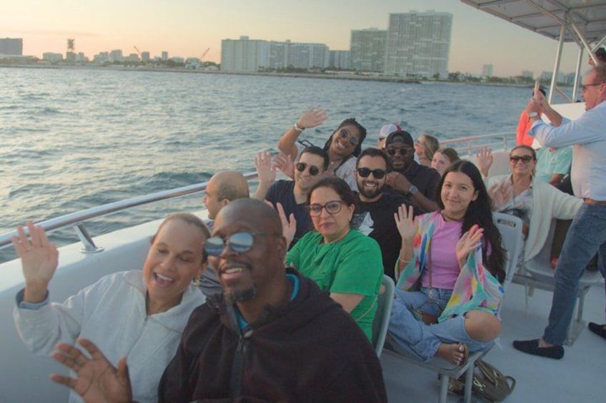 A group of people on a boat with a city skyline in the background. 1
