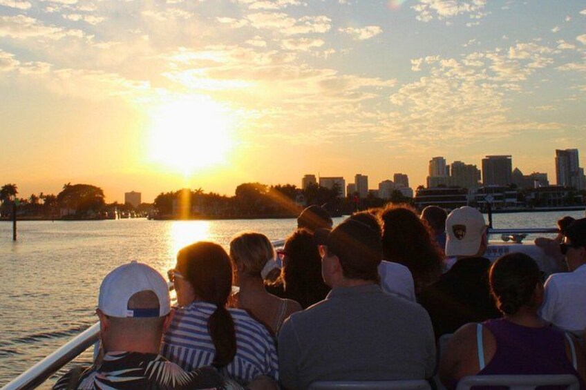 A sunset over a city skyline with a river in the foreground. 3