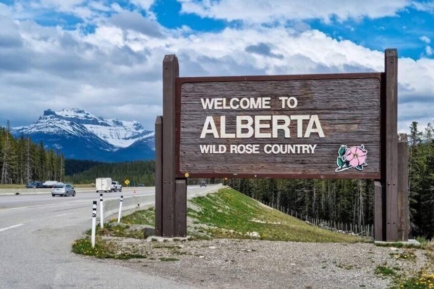 Un panneau d’accueil indiquant l’entrée en Alberta, avec une montagne en arrière-plan. 2