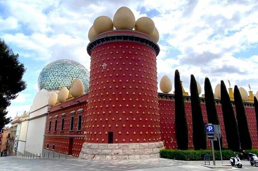 Un edificio cilíndrico rojo con decoraciones esféricas y una cúpula. 1