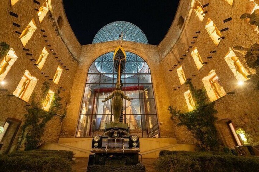 Un edificio histórico con una cúpula imponente y ventanas de arco, que presenta una estatua central y una fuente. 5