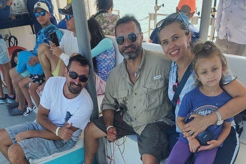 A group of people on a boat, with some wearing hats and sunglasses. 2