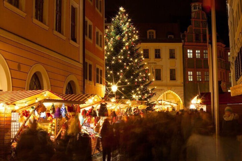A Christmas market with stalls and a large decorated Christmas tree. 3