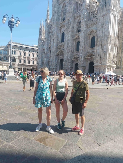 A group of people standing in front of a large cathedral with intricate architecture. 3