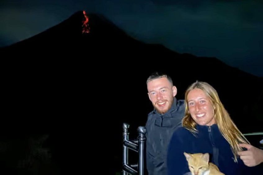 A person with a cat, a mountain, and a red light at the peak. 5